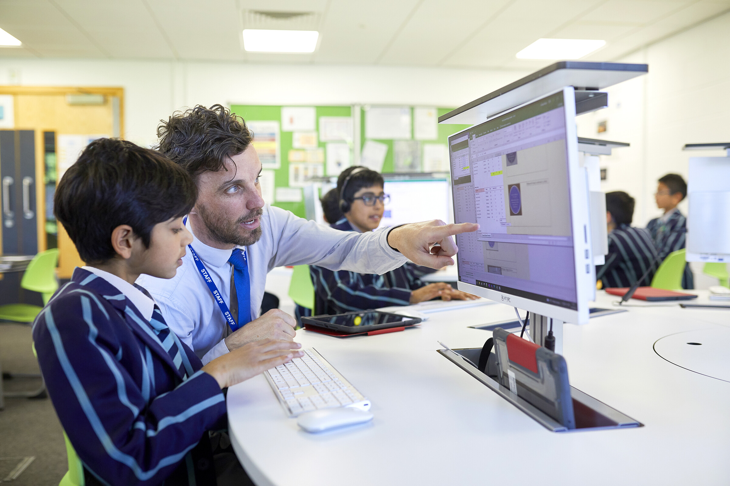 A St Martin's student and a teacher at a computer, with the teacher pointing to the screen.