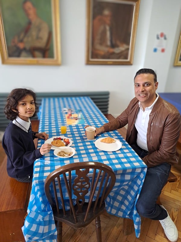 A father and son sitting at a dining table for breakfast at St Martin's School.